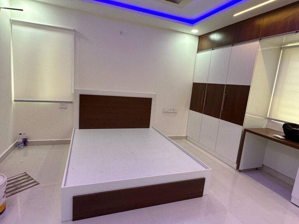Bedroom interior with blue LED false ceiling and wooden headboard by SB Interior Solutions Hyderabad