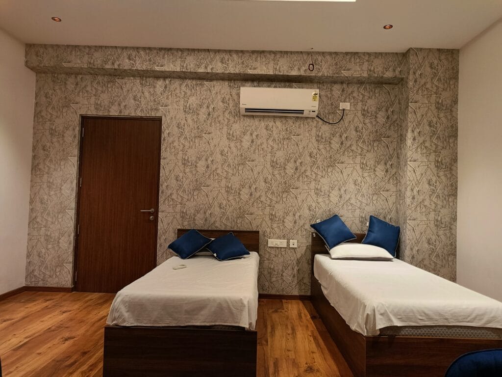 Bedroom interior with textured stone wall, wooden bed and split AC by SB Interior Solutions Hyderabad