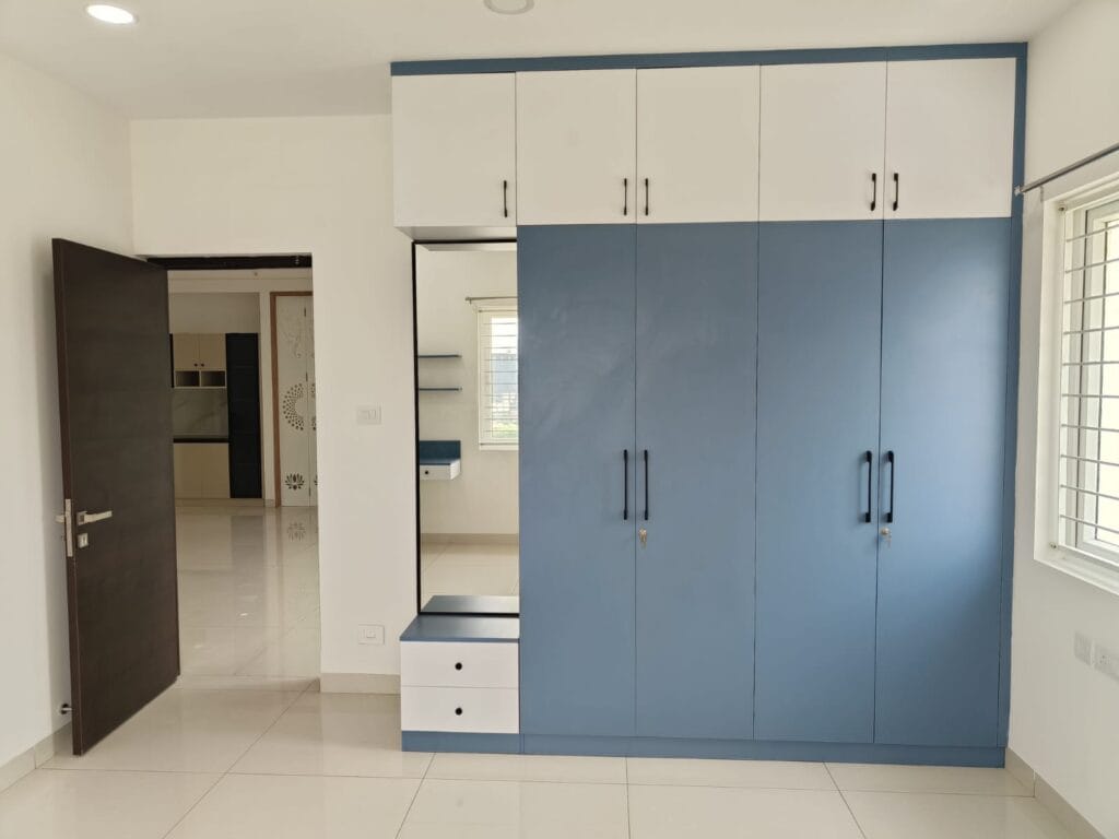 Three-door modular wardrobe in blue and white with mirror panel by SB Interior Solutions Hyderabad
